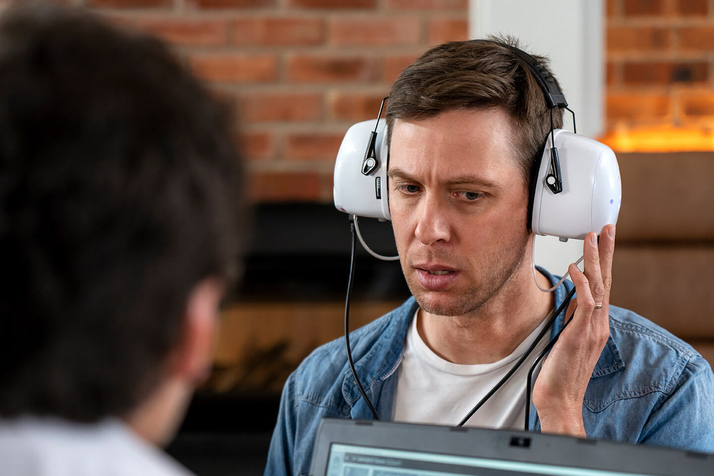 A veteran undergoing a hearing evaluation with a professional boothless audiometer headset